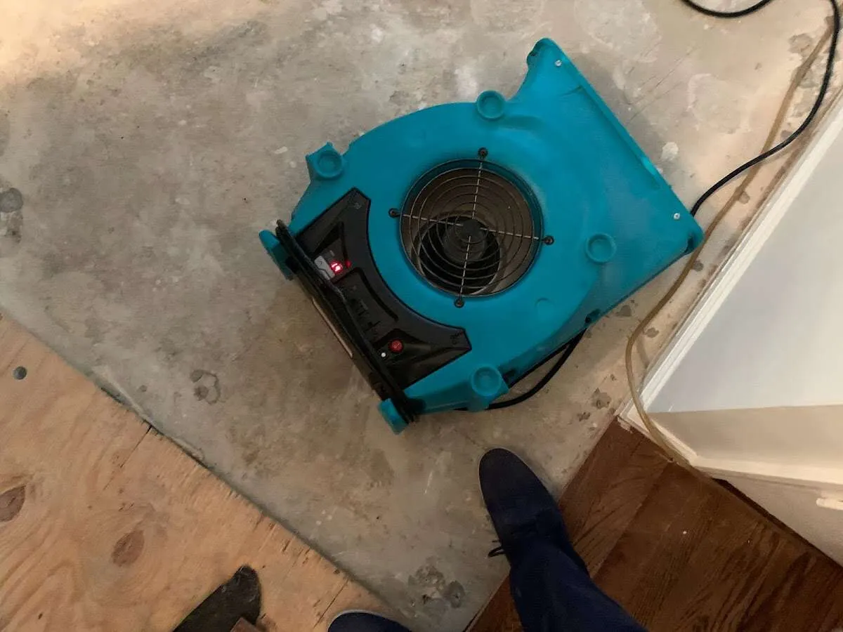 Air mover drying subfloor during Leak Detection & Repair in Piqua